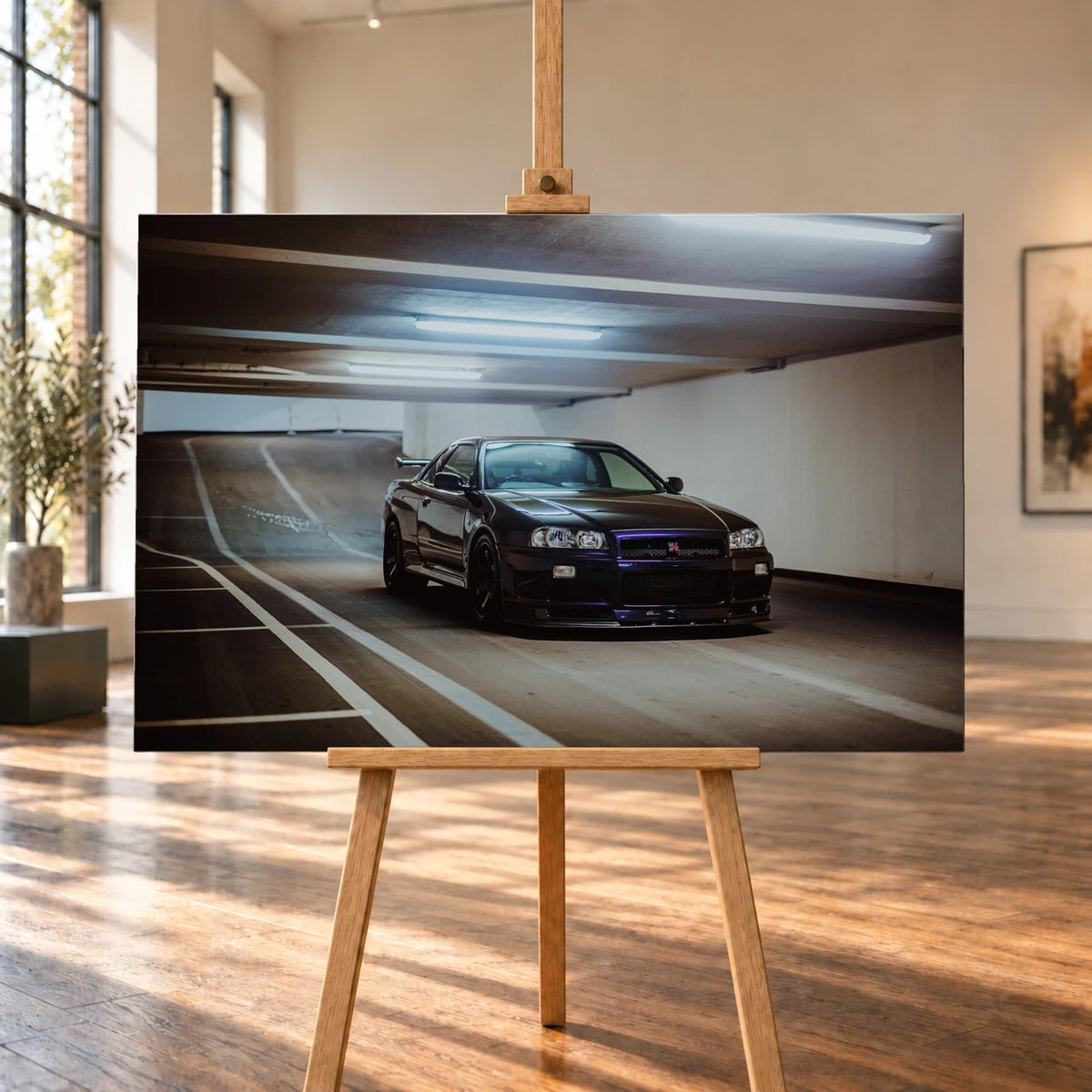 Der Nissan Skyline R34 steht tief und breit in der Kurve eines Parkhauses; Front, Seitenschweller und violette Akzente sind klar sichtbar. Motiv „Violet Story“ als Leinwand-Wandbild, auf einer Holzstaffelei in einem hellen Galerieraum.