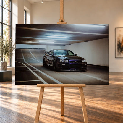 Der Nissan Skyline R34 steht tief und breit in der Kurve eines Parkhauses; Front, Seitenschweller und violette Akzente sind klar sichtbar. Motiv „Violet Story“ als Leinwand-Wandbild, auf einer Holzstaffelei in einem hellen Galerieraum.