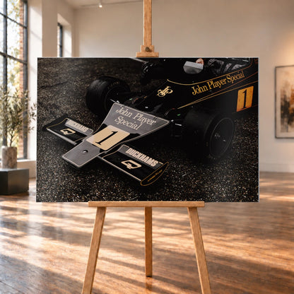 Die Nahaufnahme zeigt die spitze Front des Lotus 76 mit goldener John-Player-Special-Lackierung und großer Startnummer 1. Motiv „Apex Story“ als Alu gebürstet-Wandbild, auf einer Holzstaffelei in einem hellen Galerieraum.