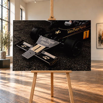 Die Nahaufnahme zeigt die spitze Front des Lotus 76 mit goldener John-Player-Special-Lackierung und großer Startnummer 1. Motiv „Apex Story“ als Leinwand-Wandbild, auf einer Holzstaffelei in einem hellen Galerieraum.