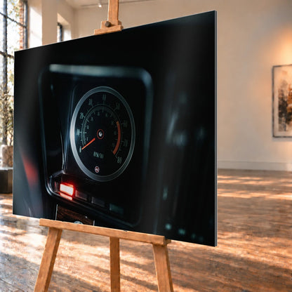 Ein einzelner Rundinstrument-Zähler leuchtet im dunklen Innenraum des Camaro Yenko; rote Kontrollleuchte und Skala sind klar sichtbar. Motiv „Silver Moment“ als Alu gebürstet-Wandbild, schräg von der Seite auf einer Holzstaffelei.