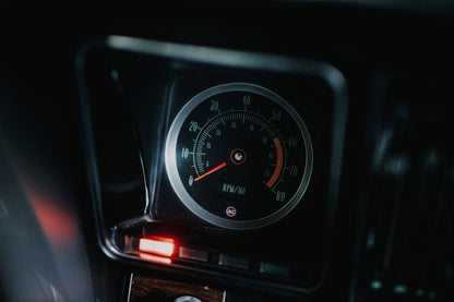 Ein einzelner Rundinstrument-Zähler leuchtet im dunklen Innenraum des Camaro Yenko; rote Kontrollleuchte und Skala sind klar sichtbar. Originalmotiv „Silver Moment“ im Querformat.