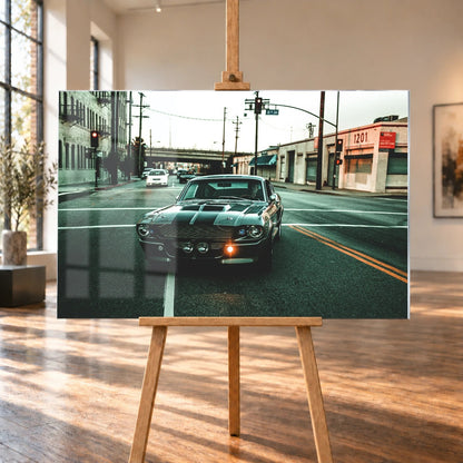 Eleanor fährt frontal über eine leere Stadtstraße; Laternen, Industriegebäude und kühles Morgenlicht rahmen die Doppelstreifen ein. Motiv „Screen Echo 2“ als Acrylglas-Wandbild, auf einer Holzstaffelei in einem hellen Galerieraum.