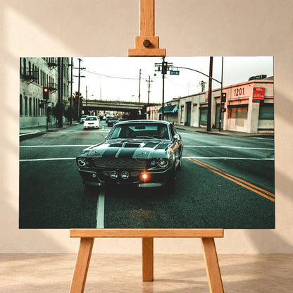 Eleanor fährt frontal über eine leere Stadtstraße; Laternen, Industriegebäude und kühles Morgenlicht rahmen die Doppelstreifen ein. Motiv „Screen Echo 2“ als Leinwand-Wandbild, frontal auf einer Holzstaffelei.