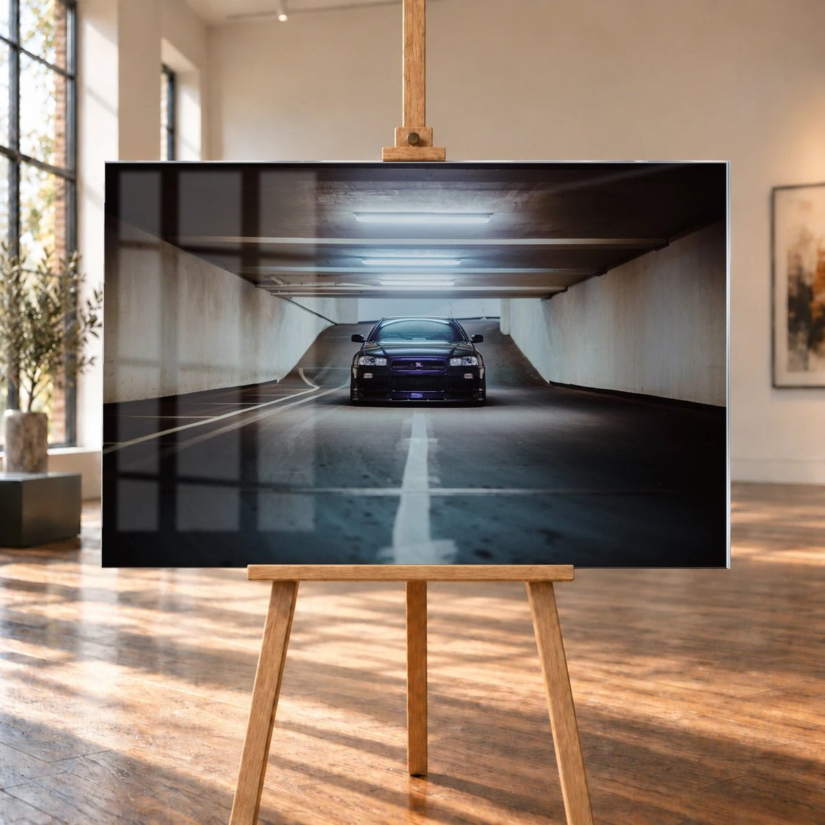 Der violette Nissan Skyline R34 steht frontal und klein am Ende einer langen, symmetrischen Parkhaustunnel-Achse; die helle Mittellinie führt direkt auf das Fahrzeug zu. Motiv „Purple Depth“ als Acrylglas-Wandbild, auf einer Holzstaffelei in einem hellen Galerieraum.