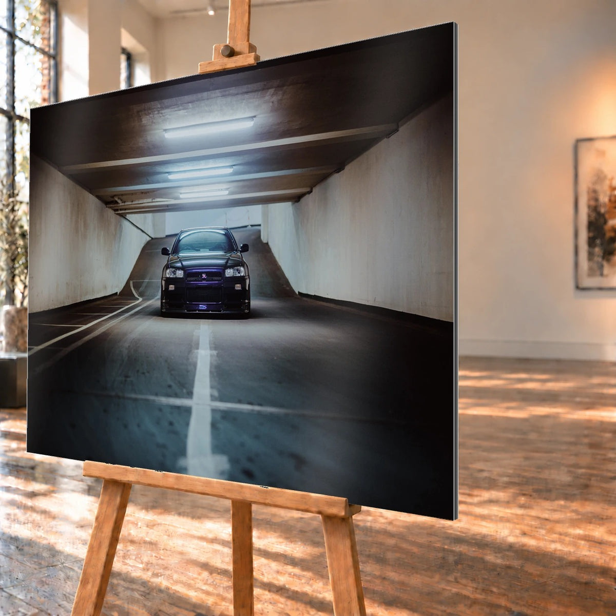 Der violette Nissan Skyline R34 steht frontal und klein am Ende einer langen, symmetrischen Parkhaustunnel-Achse; die helle Mittellinie führt direkt auf das Fahrzeug zu. Motiv „Purple Depth“ als Alu gebürstet-Wandbild, schräg von der Seite auf einer Holzstaffelei.