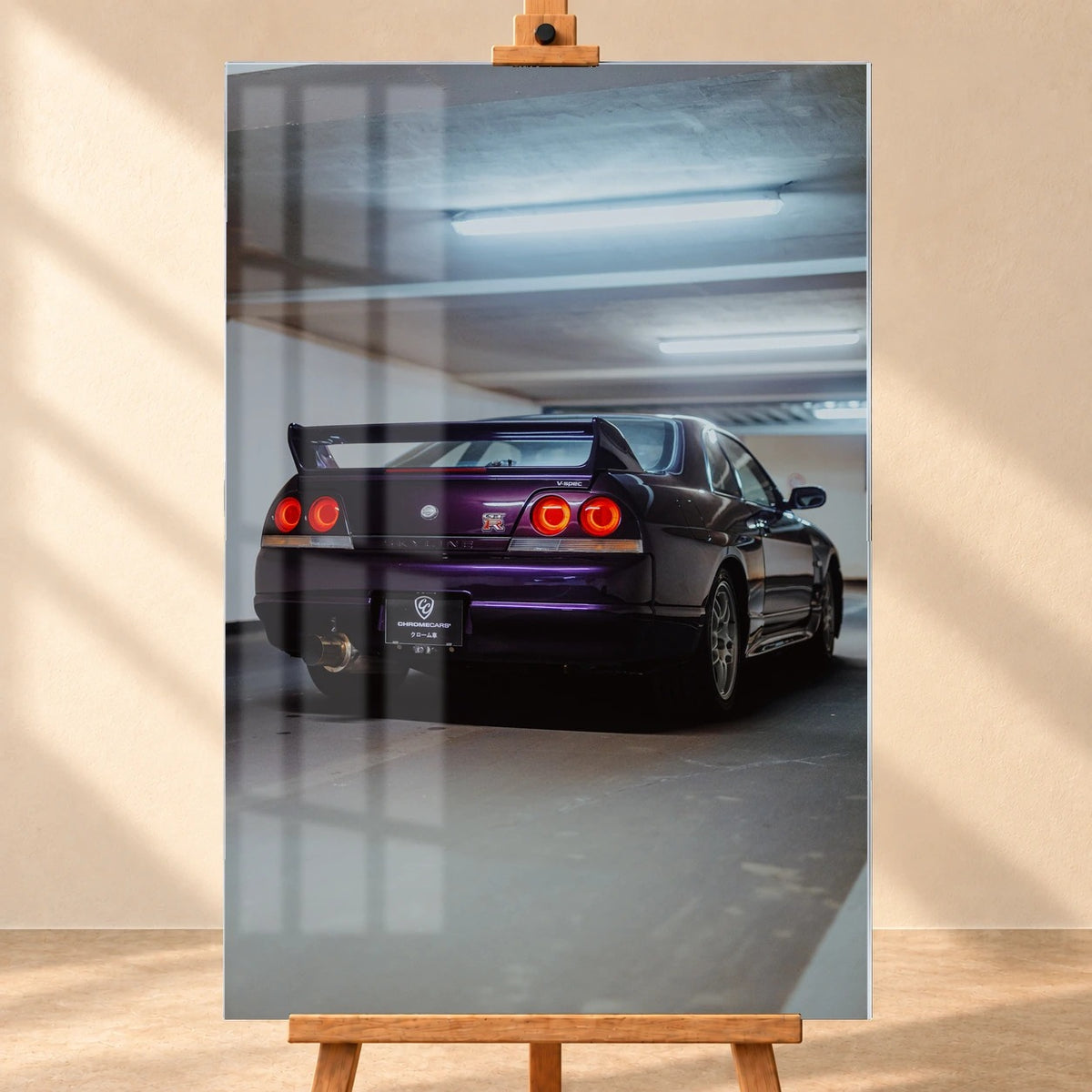 Der Nissan Skyline R33 ist hochkant von hinten fotografiert; die vier roten Rundlichter leuchten unter langen Neonröhren. Motiv „Neon Spirit“ als Acrylglas-Wandbild, frontal auf einer Holzstaffelei.