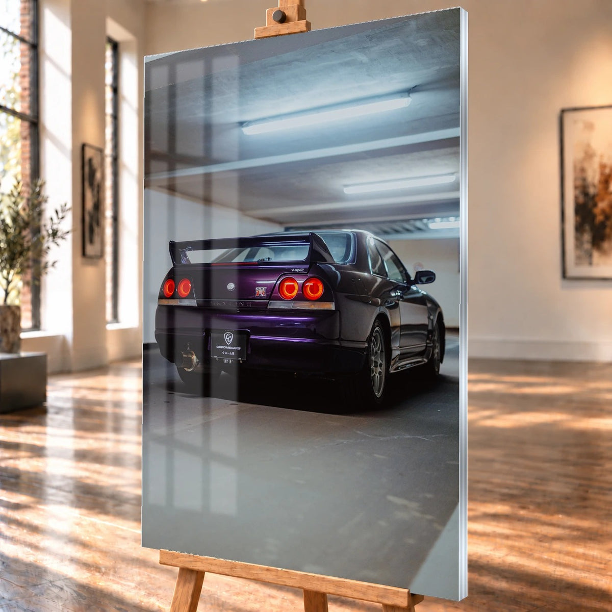 Der Nissan Skyline R33 ist hochkant von hinten fotografiert; die vier roten Rundlichter leuchten unter langen Neonröhren. Motiv „Neon Spirit“ als Acrylglas-Wandbild, schräg von der Seite auf einer Holzstaffelei.