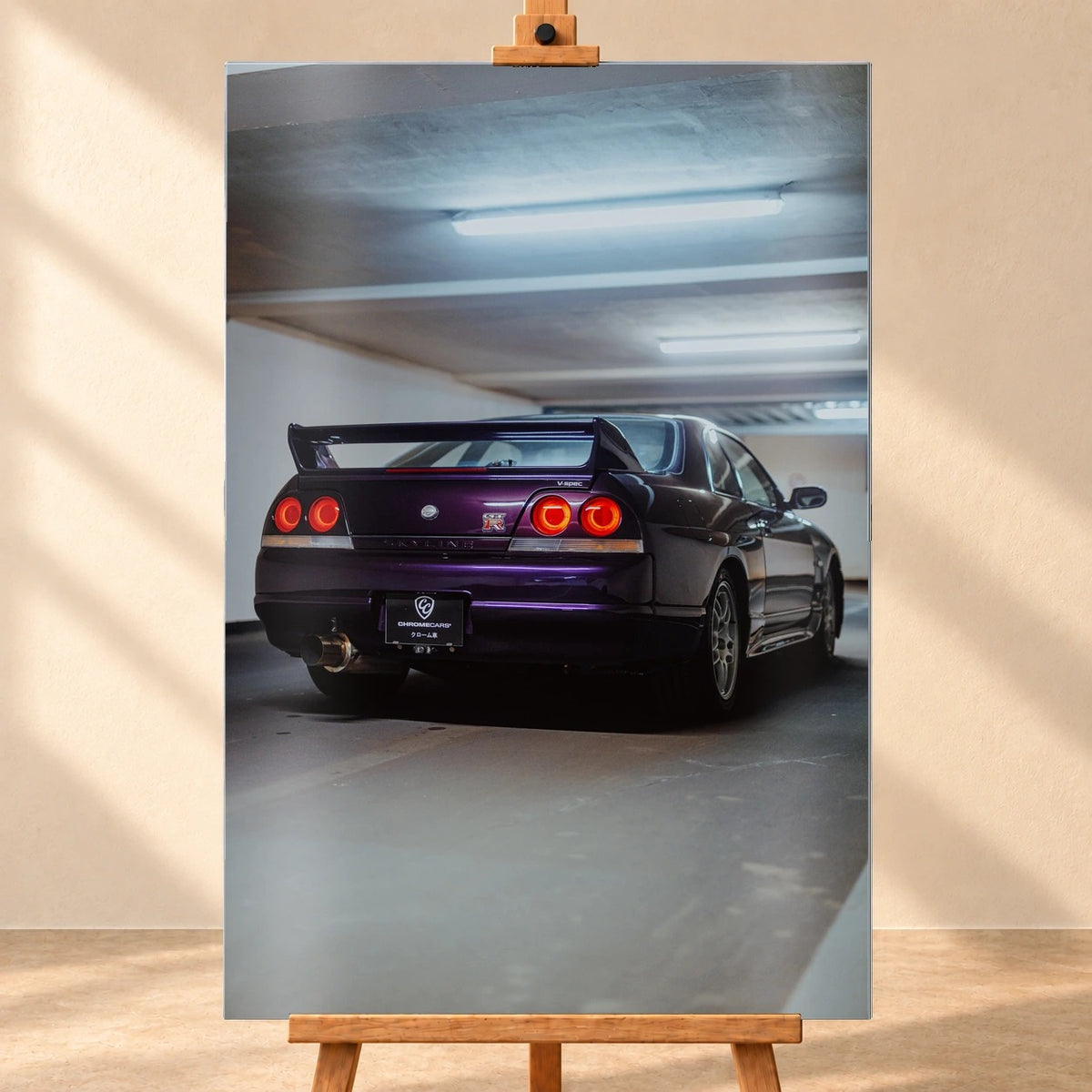 Der Nissan Skyline R33 ist hochkant von hinten fotografiert; die vier roten Rundlichter leuchten unter langen Neonröhren. Motiv „Neon Spirit“ als Alu gebürstet-Wandbild, frontal auf einer Holzstaffelei.