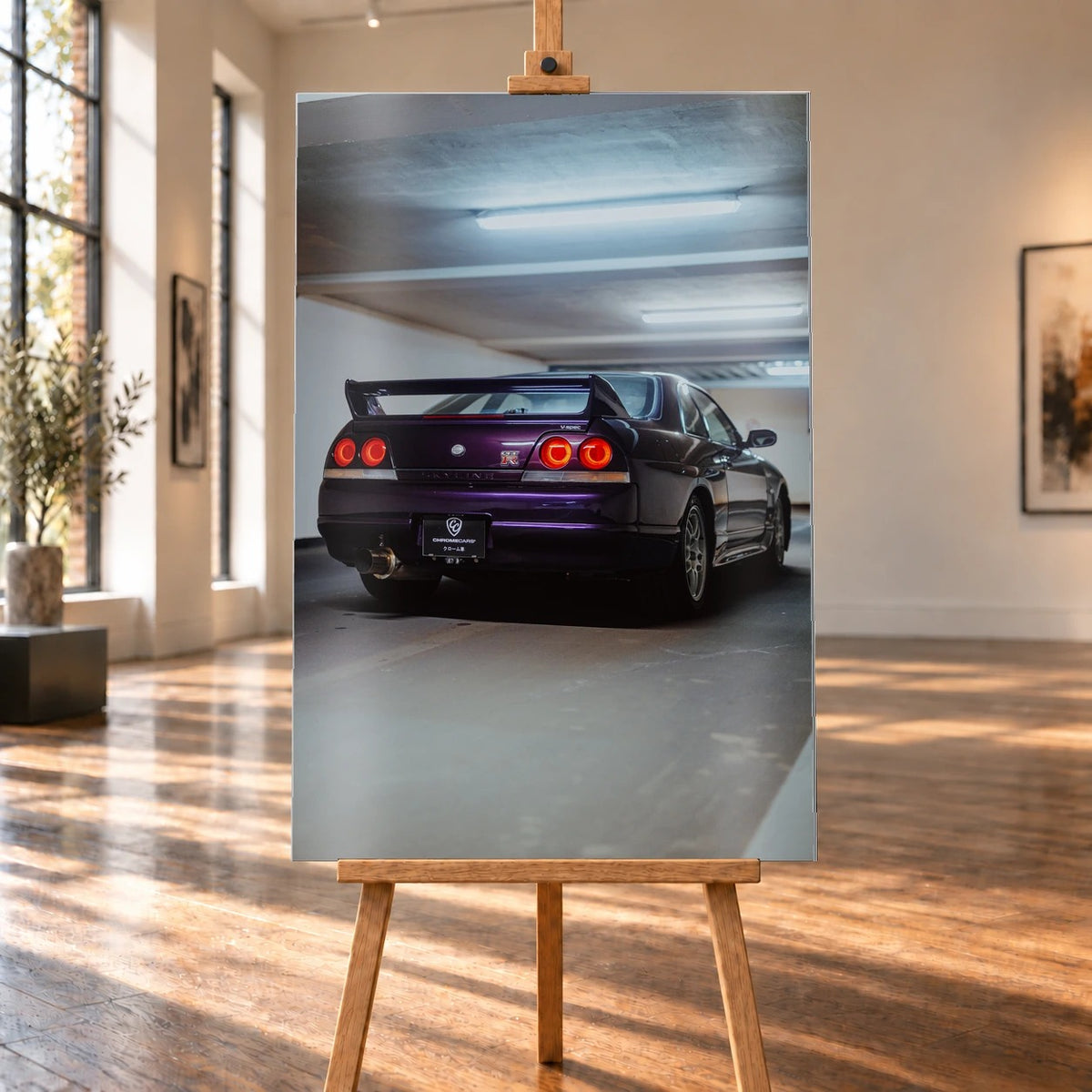 Der Nissan Skyline R33 ist hochkant von hinten fotografiert; die vier roten Rundlichter leuchten unter langen Neonröhren. Motiv „Neon Spirit“ als Alu gebürstet-Wandbild, auf einer Holzstaffelei in einem hellen Galerieraum.
