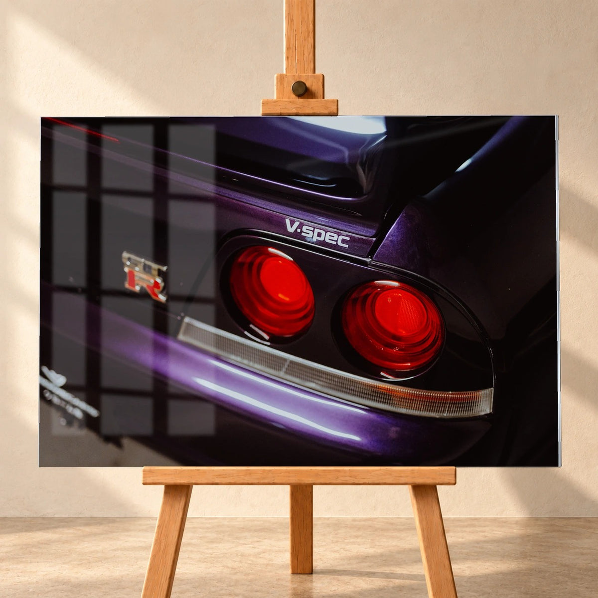 Eine enge Heckaufnahme zeigt zwei rote Rundlichter, GT-R- und V-Spec-Schriftzug sowie den violetten Lack des Nissan Skyline R33. Motiv „Neon Presence“ als Acrylglas-Wandbild, frontal auf einer Holzstaffelei.