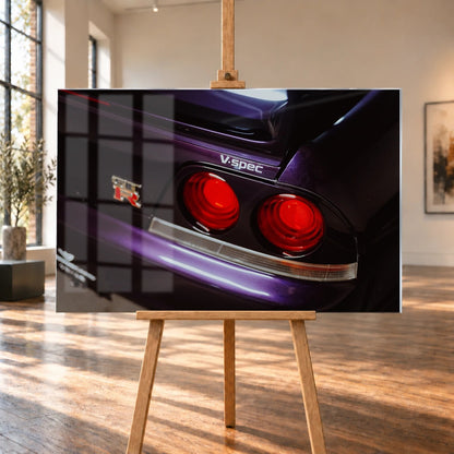 Eine enge Heckaufnahme zeigt zwei rote Rundlichter, GT-R- und V-Spec-Schriftzug sowie den violetten Lack des Nissan Skyline R33. Motiv „Neon Presence“ als Acrylglas-Wandbild, auf einer Holzstaffelei in einem hellen Galerieraum.