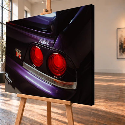 Eine enge Heckaufnahme zeigt zwei rote Rundlichter, GT-R- und V-Spec-Schriftzug sowie den violetten Lack des Nissan Skyline R33. Motiv „Neon Presence“ als Leinwand-Wandbild, schräg von der Seite auf einer Holzstaffelei.