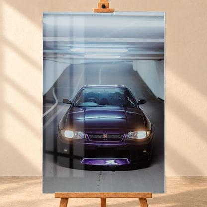 Die Front des Nissan Skyline R33 füllt das Hochformat; Scheinwerfer, Kühlergrill und der violette Frontsplitter liegen im kalten Deckenlicht. Motiv „Neon Pulse“ als Acrylglas-Wandbild, frontal auf einer Holzstaffelei.