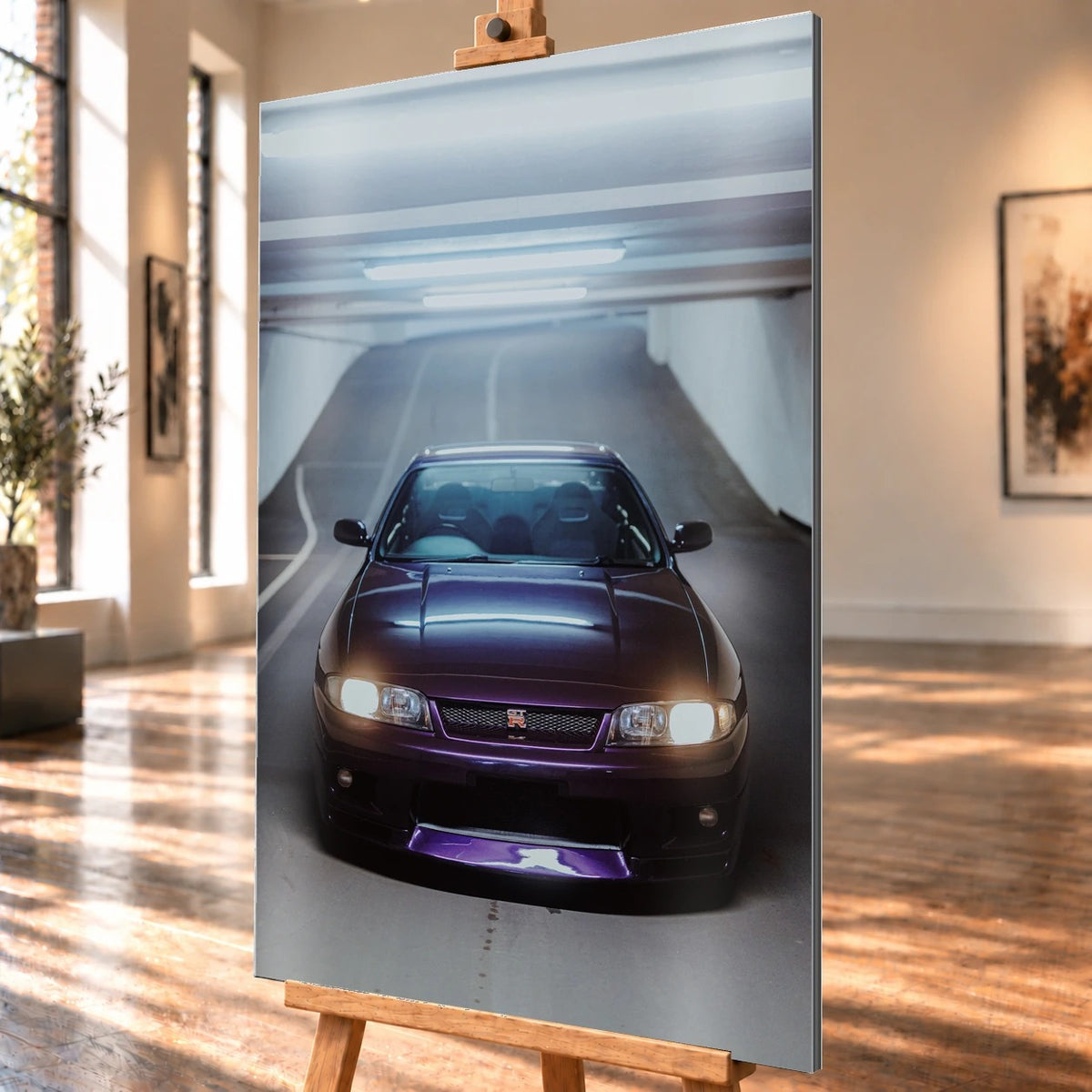 Die Front des Nissan Skyline R33 füllt das Hochformat; Scheinwerfer, Kühlergrill und der violette Frontsplitter liegen im kalten Deckenlicht. Motiv „Neon Pulse“ als Alu gebürstet-Wandbild, schräg von der Seite auf einer Holzstaffelei.