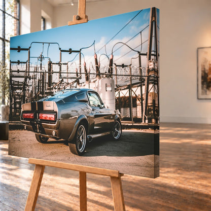 Eleanor steht schräg von hinten vor einem Umspannwerk; Masten, Leitungen und warme Sonne bilden einen technischen Hintergrund. Motiv „Road Moment“ als Leinwand-Wandbild, schräg von der Seite auf einer Holzstaffelei.
