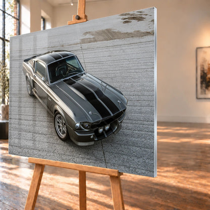 Eleanor ist aus erhöhter Perspektive schräg von vorn zu sehen; silberne Karosserie und schwarze Doppelstreifen füllen die freie Asphaltfläche. Motiv „Cinematic Pulse“ als Acrylglas-Wandbild, schräg von der Seite auf einer Holzstaffelei.