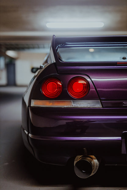 Die vertikale Detailaufnahme zeigt Heckleuchte, violetten Stoßfänger und großes Auspuffendrohr des Nissan Skyline R33. Originalmotiv „Skyline Rhythm“ im Hochformat.
