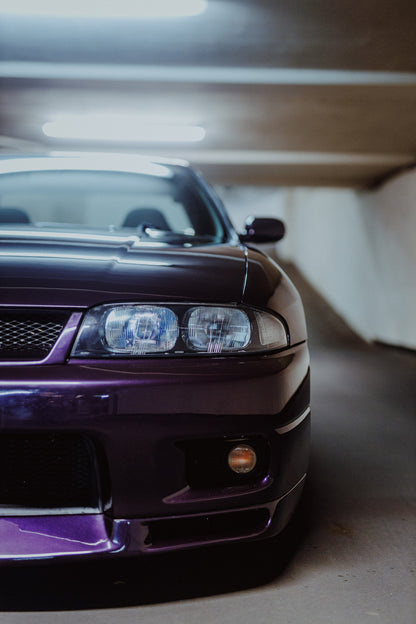 Die Front des Nissan Skyline R33 ist grafisch angeschnitten; ein Scheinwerfer, Grill und violette Frontpartie teilen das Bild. Originalmotiv „Urban Rhythm“ im Hochformat.