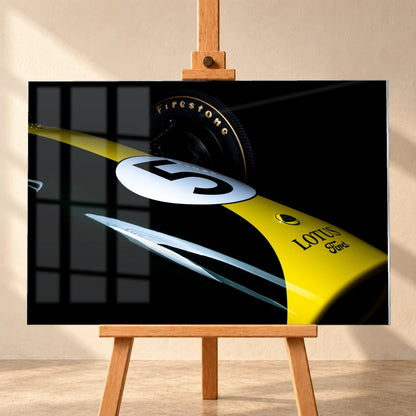 Eine enge, fast abstrakte Detailaufnahme zeigt grün-gelbe Lotus-49-Lackierung, weiße Startnummer und Reifenflanke vor schwarzem Hintergrund. Motiv „Fast Moment“ als Acrylglas-Wandbild, frontal auf einer Holzstaffelei.