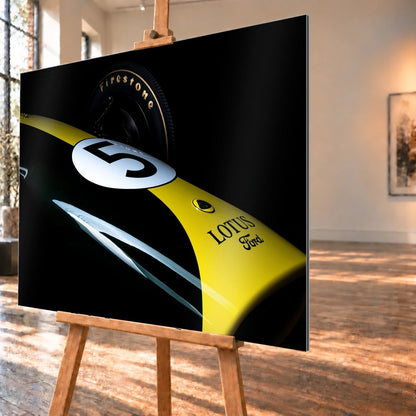 Eine enge, fast abstrakte Detailaufnahme zeigt grün-gelbe Lotus-49-Lackierung, weiße Startnummer und Reifenflanke vor schwarzem Hintergrund. Motiv „Fast Moment“ als Alu gebürstet-Wandbild, schräg von der Seite auf einer Holzstaffelei.