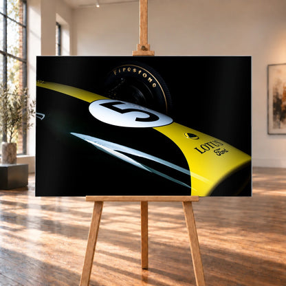 Eine enge, fast abstrakte Detailaufnahme zeigt grün-gelbe Lotus-49-Lackierung, weiße Startnummer und Reifenflanke vor schwarzem Hintergrund. Motiv „Fast Moment“ als Alu gebürstet-Wandbild, auf einer Holzstaffelei in einem hellen Galerieraum.