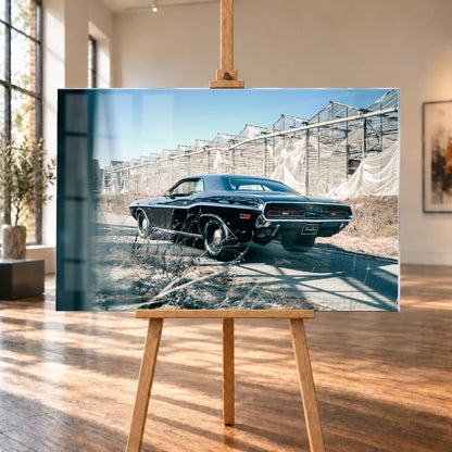 Der schwarze Dodge Challenger ist schräg von hinten auf einem Industriegelände aufgenommen; breite Karosserie und rote Rückleuchten wirken kraftvoll. Motiv „Timeless Pulse“ als Acrylglas-Wandbild, auf einer Holzstaffelei in einem hellen Galerieraum.