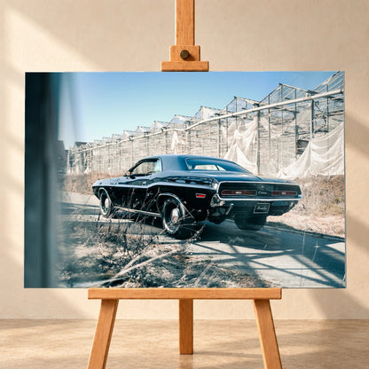 Der schwarze Dodge Challenger ist schräg von hinten auf einem Industriegelände aufgenommen; breite Karosserie und rote Rückleuchten wirken kraftvoll. Motiv „Timeless Pulse“ als Alu gebürstet-Wandbild, frontal auf einer Holzstaffelei.