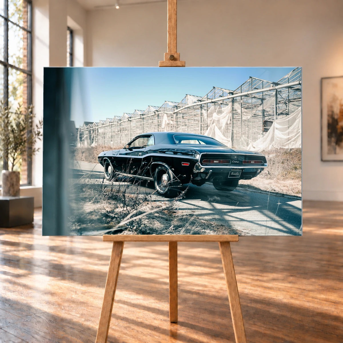 Der schwarze Dodge Challenger ist schräg von hinten auf einem Industriegelände aufgenommen; breite Karosserie und rote Rückleuchten wirken kraftvoll. Motiv „Timeless Pulse“ als Alu gebürstet-Wandbild, auf einer Holzstaffelei in einem hellen Galerieraum.