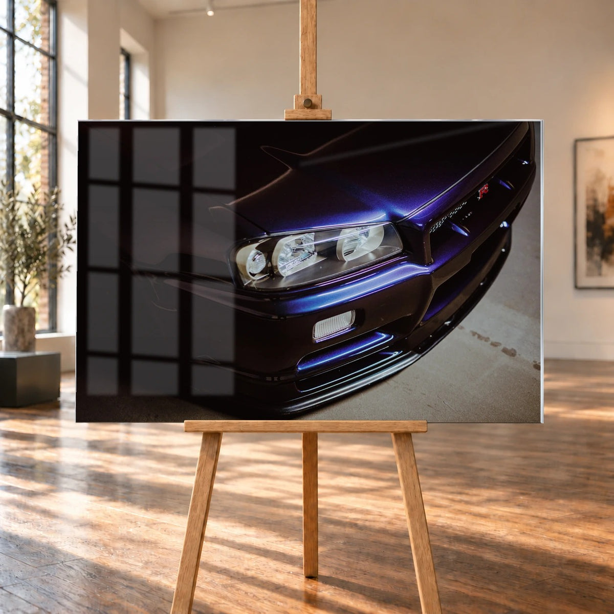 Eine schräge Nahaufnahme zeigt Scheinwerfer, Frontschürze und violette Lackkante des Nissan Skyline R34 unter hartem Neonlicht. Motiv „Skyline Presence“ als Acrylglas-Wandbild, auf einer Holzstaffelei in einem hellen Galerieraum.