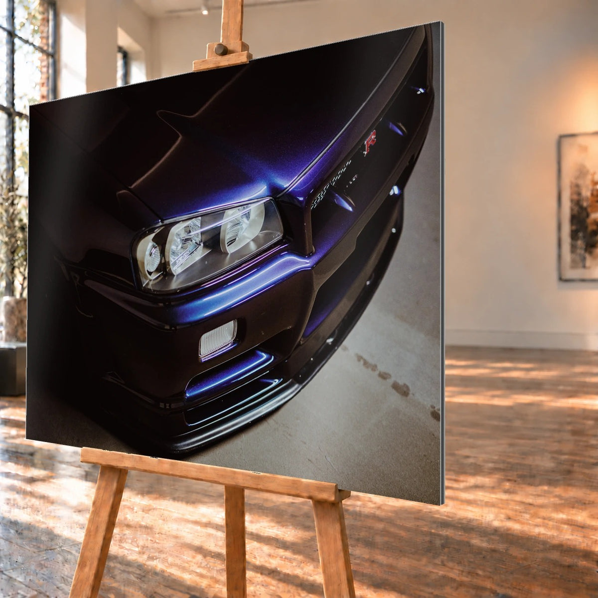 Eine schräge Nahaufnahme zeigt Scheinwerfer, Frontschürze und violette Lackkante des Nissan Skyline R34 unter hartem Neonlicht. Motiv „Skyline Presence“ als Alu gebürstet-Wandbild, schräg von der Seite auf einer Holzstaffelei.