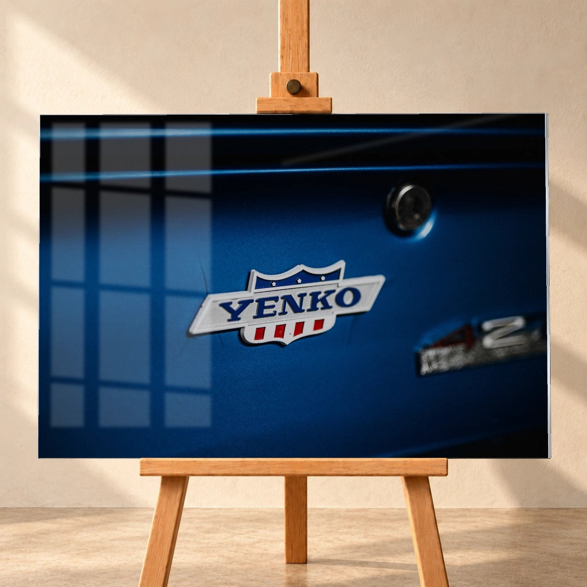 Das Yenko-Emblem sitzt als helles Detail auf der blauen Karosserie; Lack, Chrom und Schriftzug füllen die Aufnahme. Motiv „Hero Line“ als Acrylglas-Wandbild, frontal auf einer Holzstaffelei.