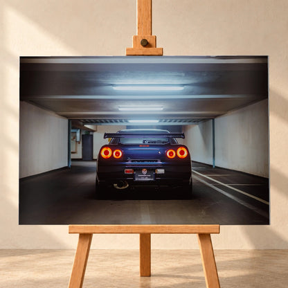Der Nissan Skyline R34 ist exakt mittig von hinten aufgenommen; vier leuchtende Rundlichter und die geraden Parkhauslinien rahmen ihn ein. Motiv „Neon Rhythm“ als Alu gebürstet-Wandbild, frontal auf einer Holzstaffelei.