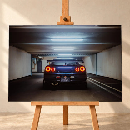 Der Nissan Skyline R34 ist exakt mittig von hinten aufgenommen; vier leuchtende Rundlichter und die geraden Parkhauslinien rahmen ihn ein. Motiv „Neon Rhythm“ als Leinwand-Wandbild, frontal auf einer Holzstaffelei.