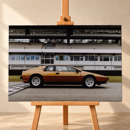 Der goldene Lotus Esprit steht streng im Seitenprofil vor der Boxenanlage; Keilform und dunkle Räder zeichnen eine klare Silhouette. Motiv „Timeless Rhythm“ als Leinwand-Wandbild, frontal auf einer Holzstaffelei.