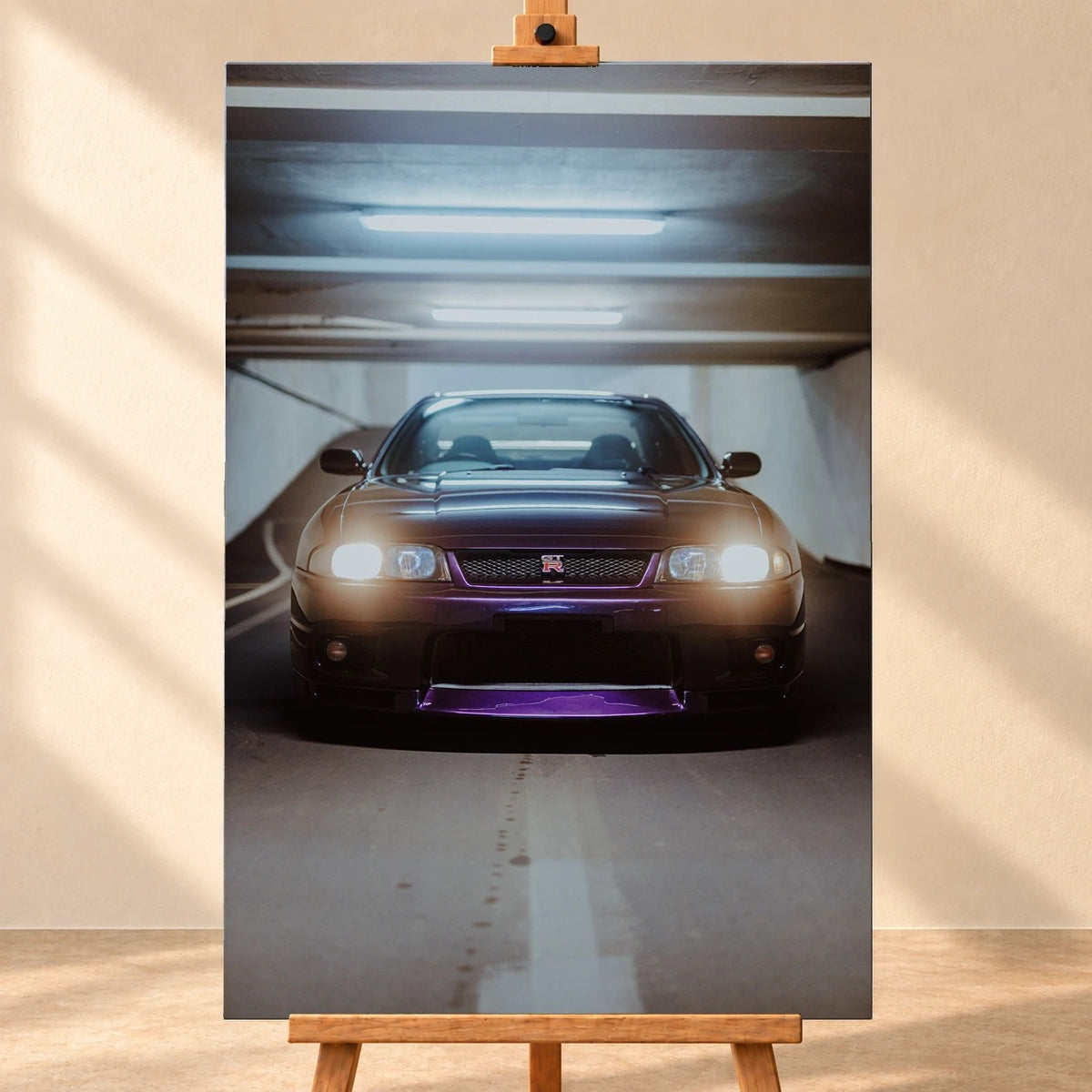 Die Front des Nissan Skyline R33 erscheint im Hochformat mit eingeschalteten Scheinwerfern; violetter Splitter und kaltes Neonlicht kontrastieren miteinander. Motiv „Midnight Depth“ als Leinwand-Wandbild, frontal auf einer Holzstaffelei.