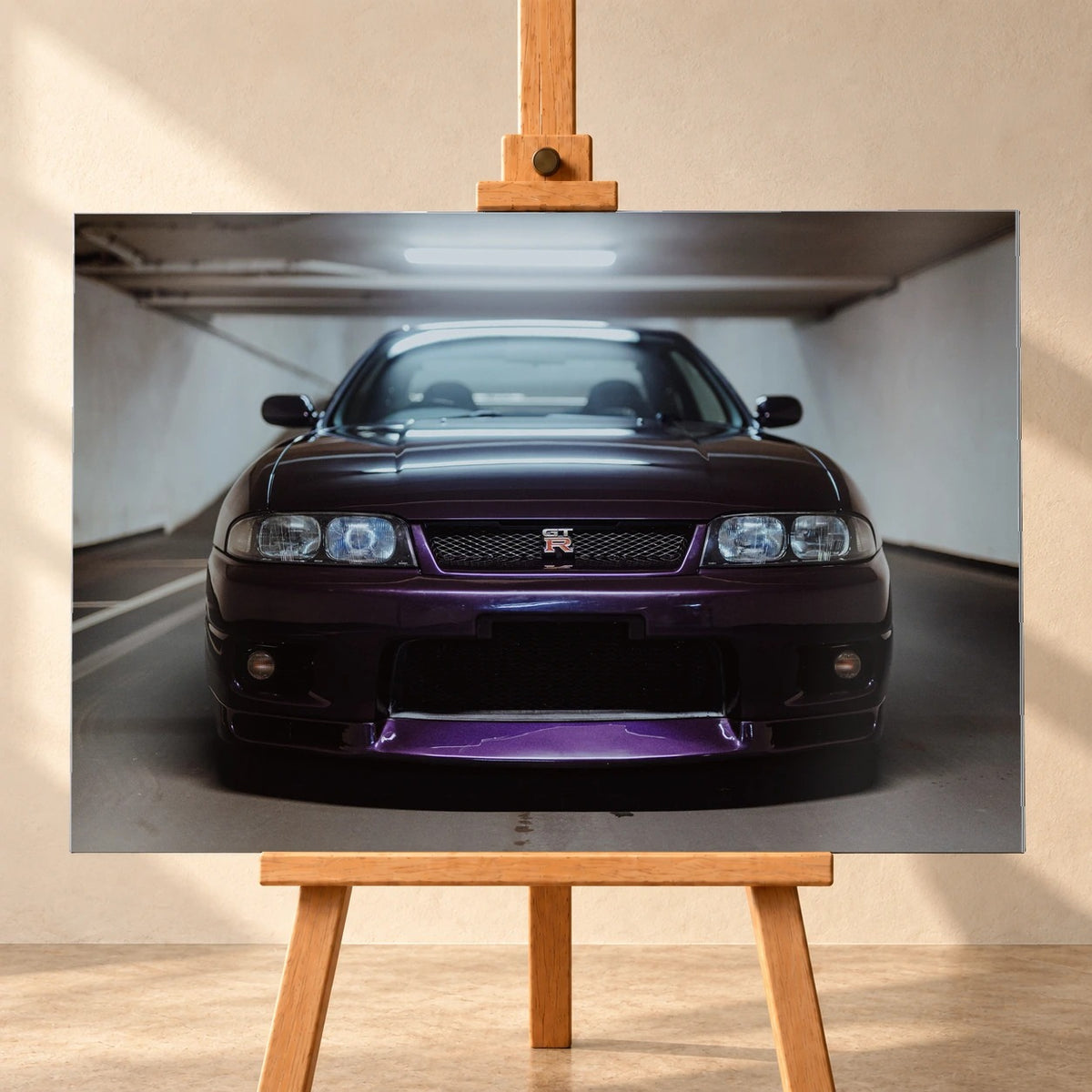 Der Nissan Skyline R33 ist frontal und nah unter Neonlicht fotografiert; Kühlergrill und violetter Splitter bilden eine klare horizontale Linie. Motiv „Skyline Moment“ als Alu gebürstet-Wandbild, frontal auf einer Holzstaffelei.