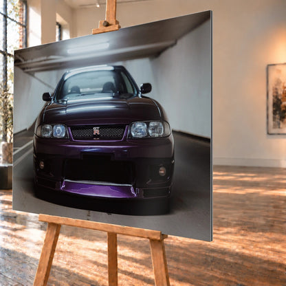 Der Nissan Skyline R33 ist frontal und nah unter Neonlicht fotografiert; Kühlergrill und violetter Splitter bilden eine klare horizontale Linie. Motiv „Skyline Moment“ als Alu gebürstet-Wandbild, schräg von der Seite auf einer Holzstaffelei.