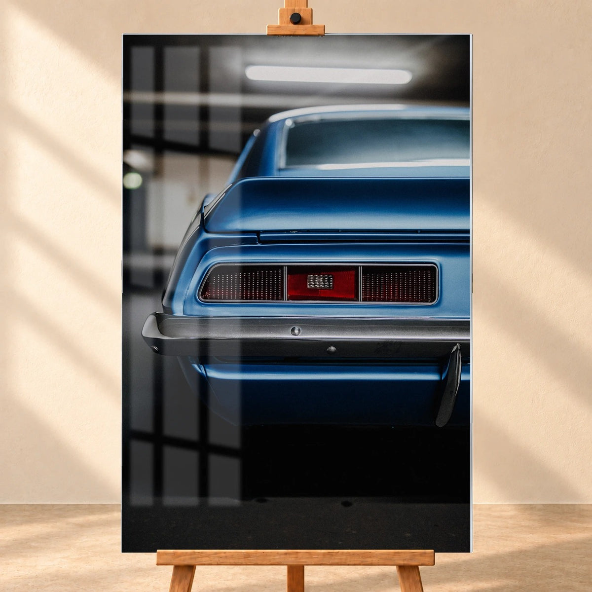 Das Heck des blauen Camaro Yenko ist eng angeschnitten; Rücklicht, Spoilerkante und schwarze Blende bilden horizontale Flächen. Motiv „Screen Focus“ als Acrylglas-Wandbild, frontal auf einer Holzstaffelei.
