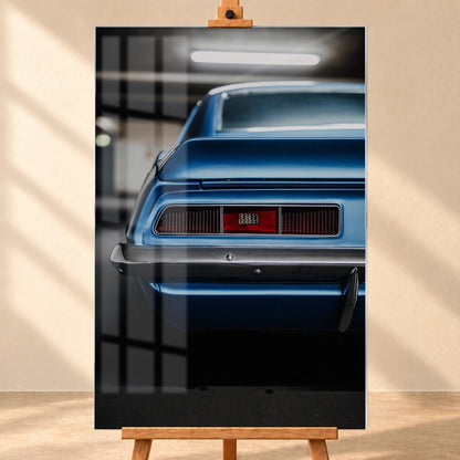 Das Heck des blauen Camaro Yenko ist eng angeschnitten; Rücklicht, Spoilerkante und schwarze Blende bilden horizontale Flächen. Motiv „Screen Focus“ als Acrylglas-Wandbild, frontal auf einer Holzstaffelei.