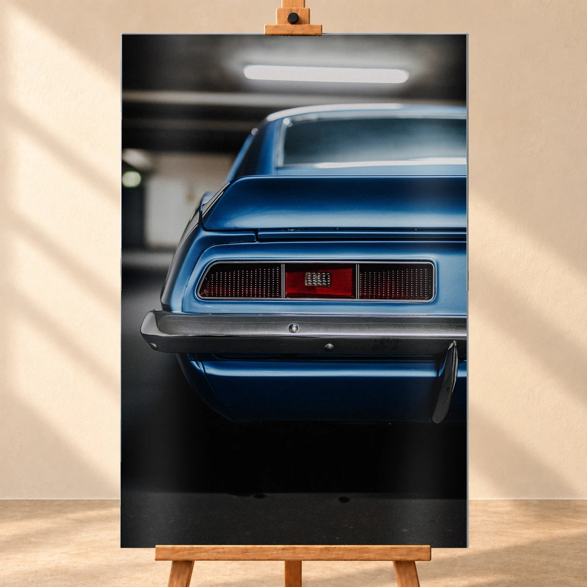 Das Heck des blauen Camaro Yenko ist eng angeschnitten; Rücklicht, Spoilerkante und schwarze Blende bilden horizontale Flächen. Motiv „Screen Focus“ als Alu gebürstet-Wandbild, frontal auf einer Holzstaffelei.