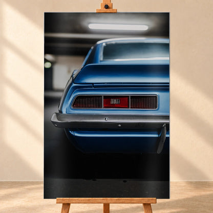 Das Heck des blauen Camaro Yenko ist eng angeschnitten; Rücklicht, Spoilerkante und schwarze Blende bilden horizontale Flächen. Motiv „Screen Focus“ als Alu gebürstet-Wandbild, frontal auf einer Holzstaffelei.