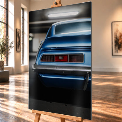 Das Heck des blauen Camaro Yenko ist eng angeschnitten; Rücklicht, Spoilerkante und schwarze Blende bilden horizontale Flächen. Motiv „Screen Focus“ als Alu gebürstet-Wandbild, schräg von der Seite auf einer Holzstaffelei.