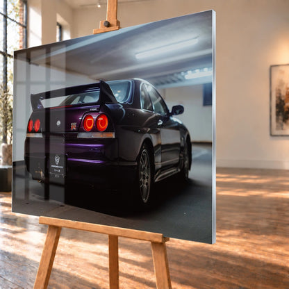 Der Nissan Skyline R33 steht schräg von hinten in einer Parkhauskurve; Rundlichter und Spoiler heben sich vom kühlen Beton ab. Motiv „Neon Story“ als Acrylglas-Wandbild, schräg von der Seite auf einer Holzstaffelei.