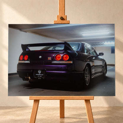 Der Nissan Skyline R33 steht schräg von hinten in einer Parkhauskurve; Rundlichter und Spoiler heben sich vom kühlen Beton ab. Motiv „Neon Story“ als Alu gebürstet-Wandbild, frontal auf einer Holzstaffelei.