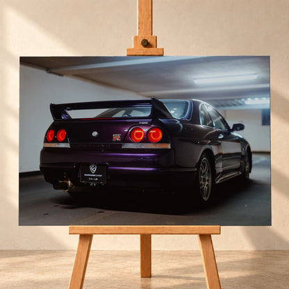 Der Nissan Skyline R33 steht schräg von hinten in einer Parkhauskurve; Rundlichter und Spoiler heben sich vom kühlen Beton ab. Motiv „Neon Story“ als Leinwand-Wandbild, frontal auf einer Holzstaffelei.