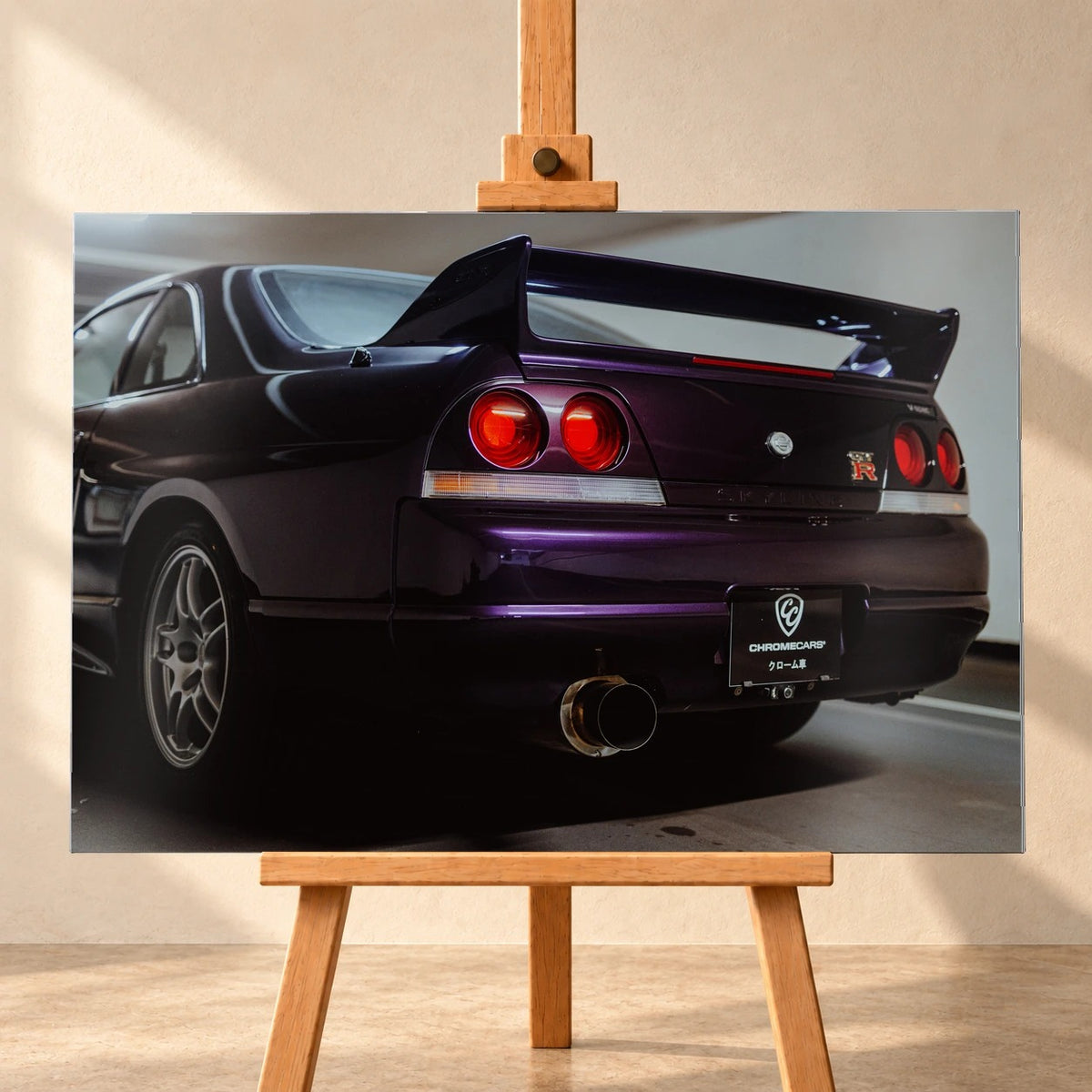 Die niedrige Heckperspektive des Nissan Skyline R33 hebt Spoiler, Rundlichter, Felgen und das große Endrohr hervor. Motiv „Skyline Drive“ als Alu gebürstet-Wandbild, frontal auf einer Holzstaffelei.