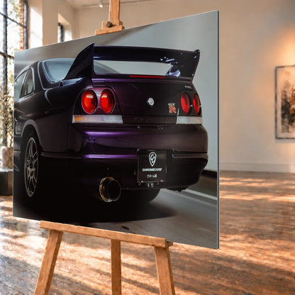 Die niedrige Heckperspektive des Nissan Skyline R33 hebt Spoiler, Rundlichter, Felgen und das große Endrohr hervor. Motiv „Skyline Drive“ als Alu gebürstet-Wandbild, schräg von der Seite auf einer Holzstaffelei.