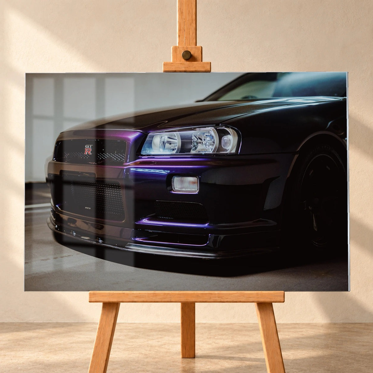 Die tiefe Nahaufnahme des Nissan Skyline R34 konzentriert sich auf Scheinwerfer, Grill und violette Frontschürze. Motiv „Skyline Motion 2“ als Acrylglas-Wandbild, frontal auf einer Holzstaffelei.