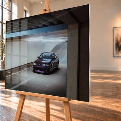 Der Nissan Skyline R33 ist schräg von vorn zwischen Betonstützen aufgenommen; violette Lackreflexe und kühles Deckenlicht bestimmen die Szene. Motiv „Skyline Motion“ als Acrylglas-Wandbild, schräg von der Seite auf einer Holzstaffelei.